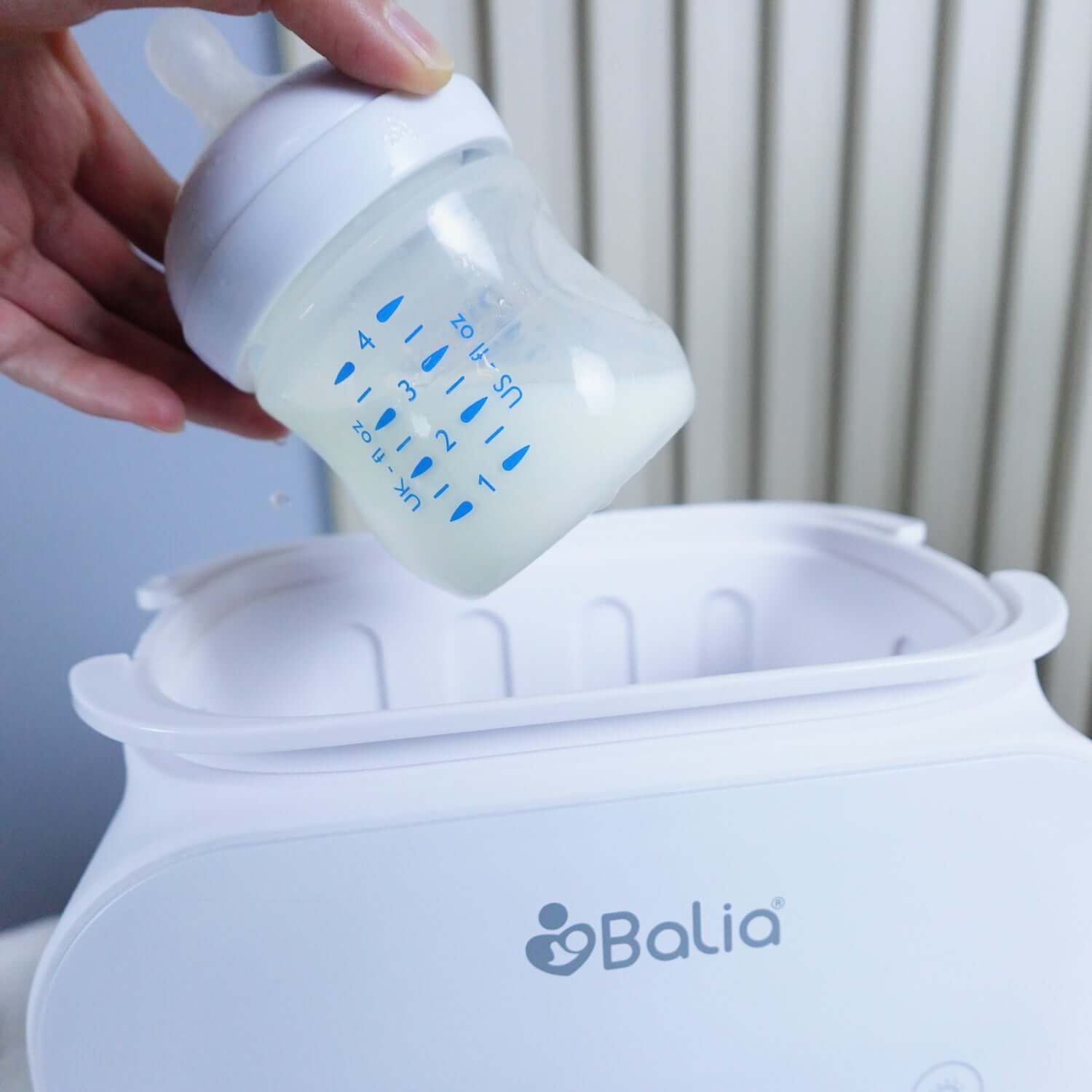 Calentador de mamaderas 4 en 1 Balia en uso con un biberón listo para calentar leche para bebé.